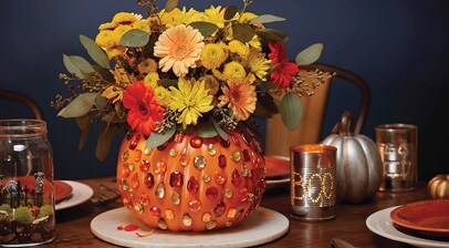 Pumpkin centerpiece with flowers on a table