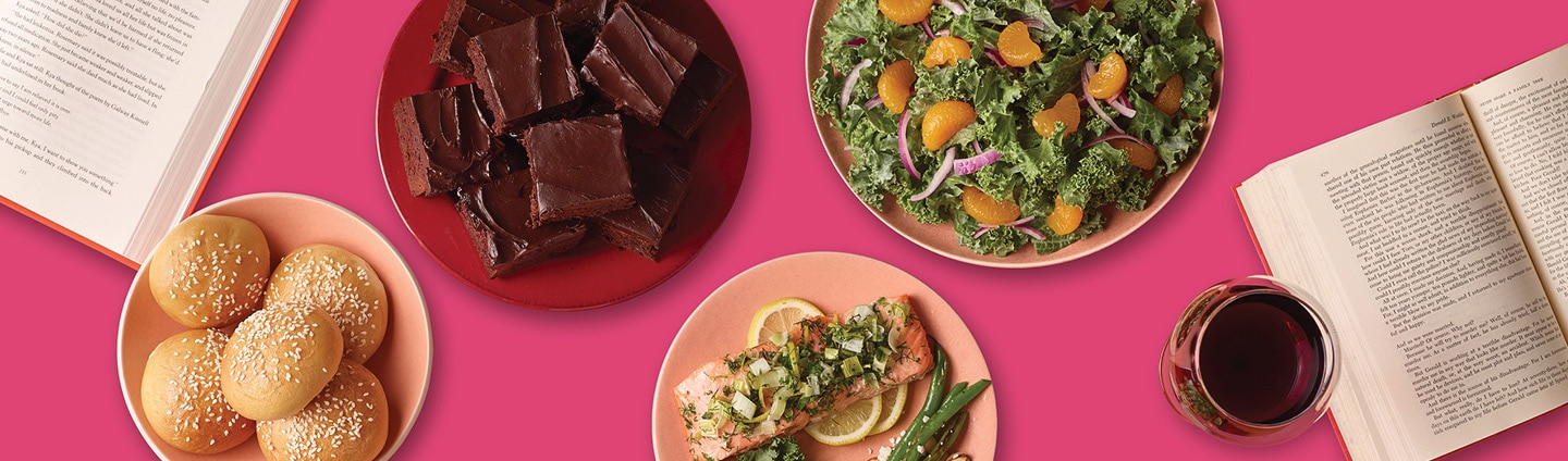 assorted potluck dishes including salmon, kale and mandarin orange salad, brownies, red wine and chapter books