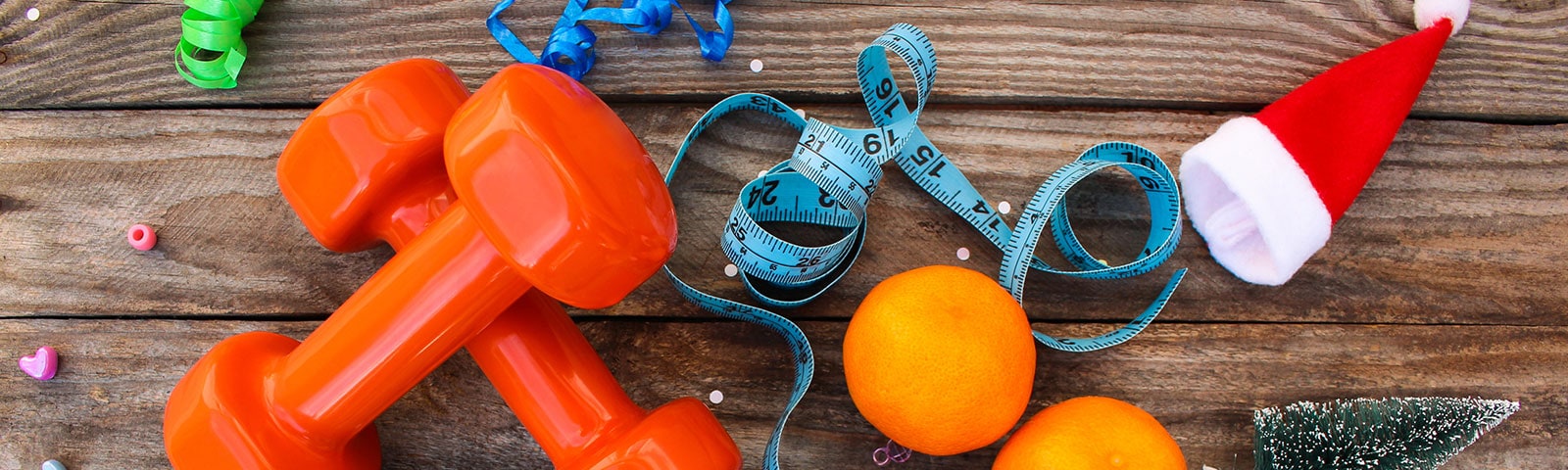 Weights and oranges on a wooden table to stay healthy Weights and oranges on a wooden table to stay healthy