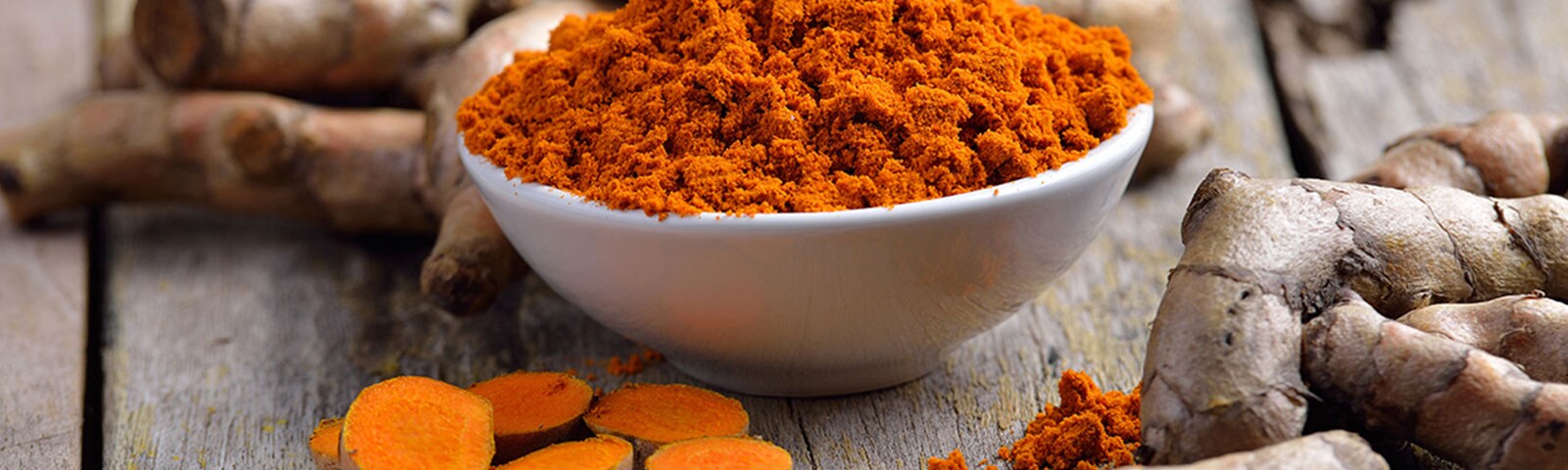 Ground turmeric in a bowl on a wooden table Ground turmeric in a bowl on a wooden table