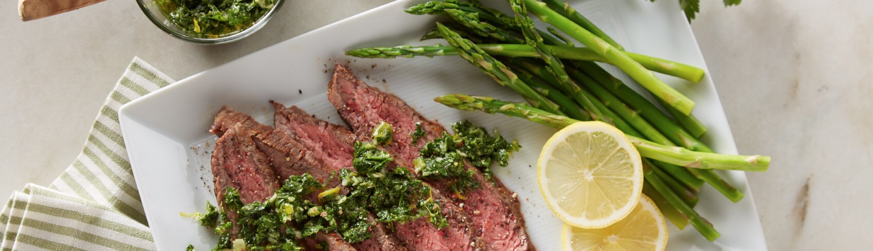 A plate with steak, asparagus and lemon slices A plate with steak, asparagus and lemon slices