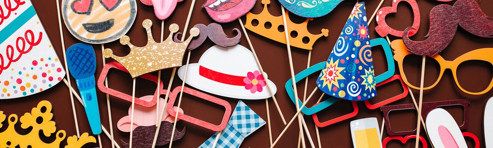Photo booth props like cutout hats and sunglasses on wooden sticks Photo booth props like cutout hats and sunglasses on wooden sticks