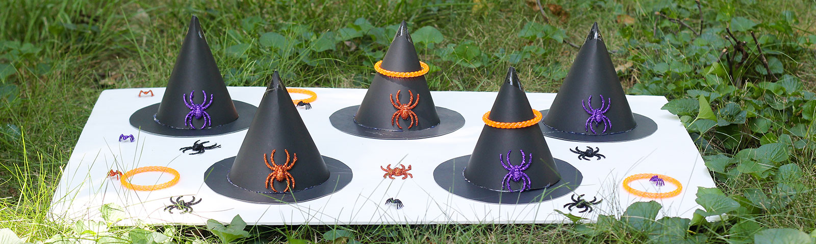 Witch Hat Ring Toss DIY game with finished witch hats and glittered plastic spiders on a lawn Witch Hat Ring Toss DIY game with finished witch hats and glittered plastic spiders on a lawn