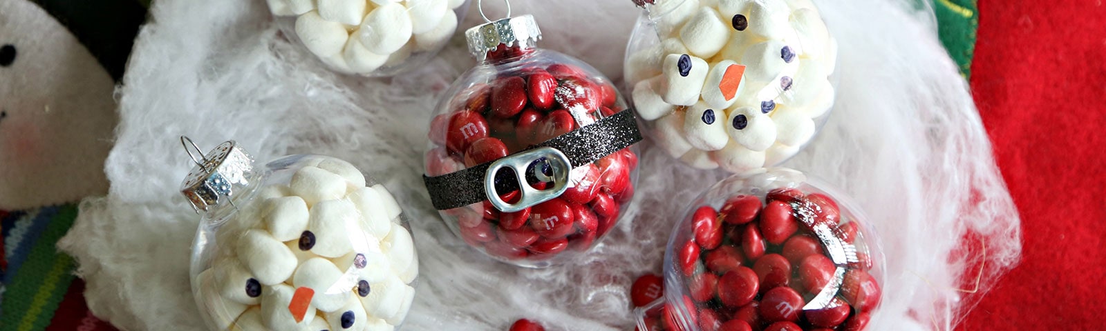 Santa and snowman decorated plastic ornaments filled with red M&M’s and miniature marshmallows