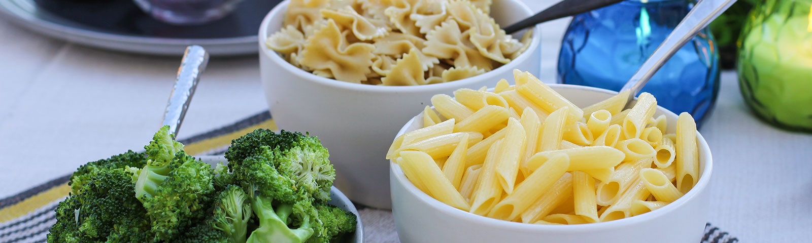 Cooked pasta and broccoli in separate bowls