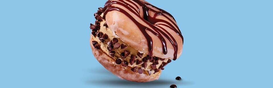 Glazed donut sandwich with coffee flavored ice cream in the middle and chocolate syrup and chocolate chips