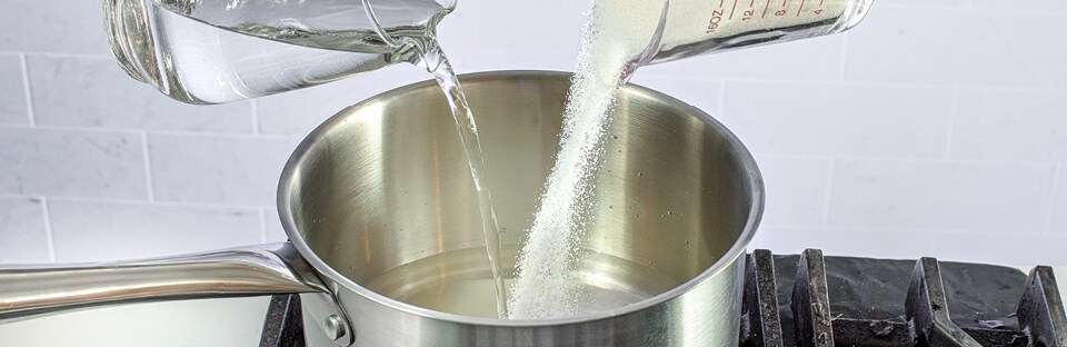 saucepan with water and sugar being poured in