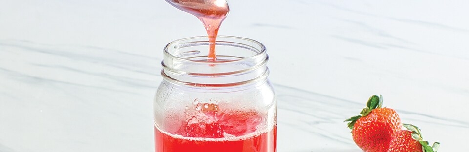 A spoonful of simple syrup from a mason jar.